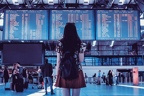 ex-expa young woman looking timetable at the airport - Studio Psiché